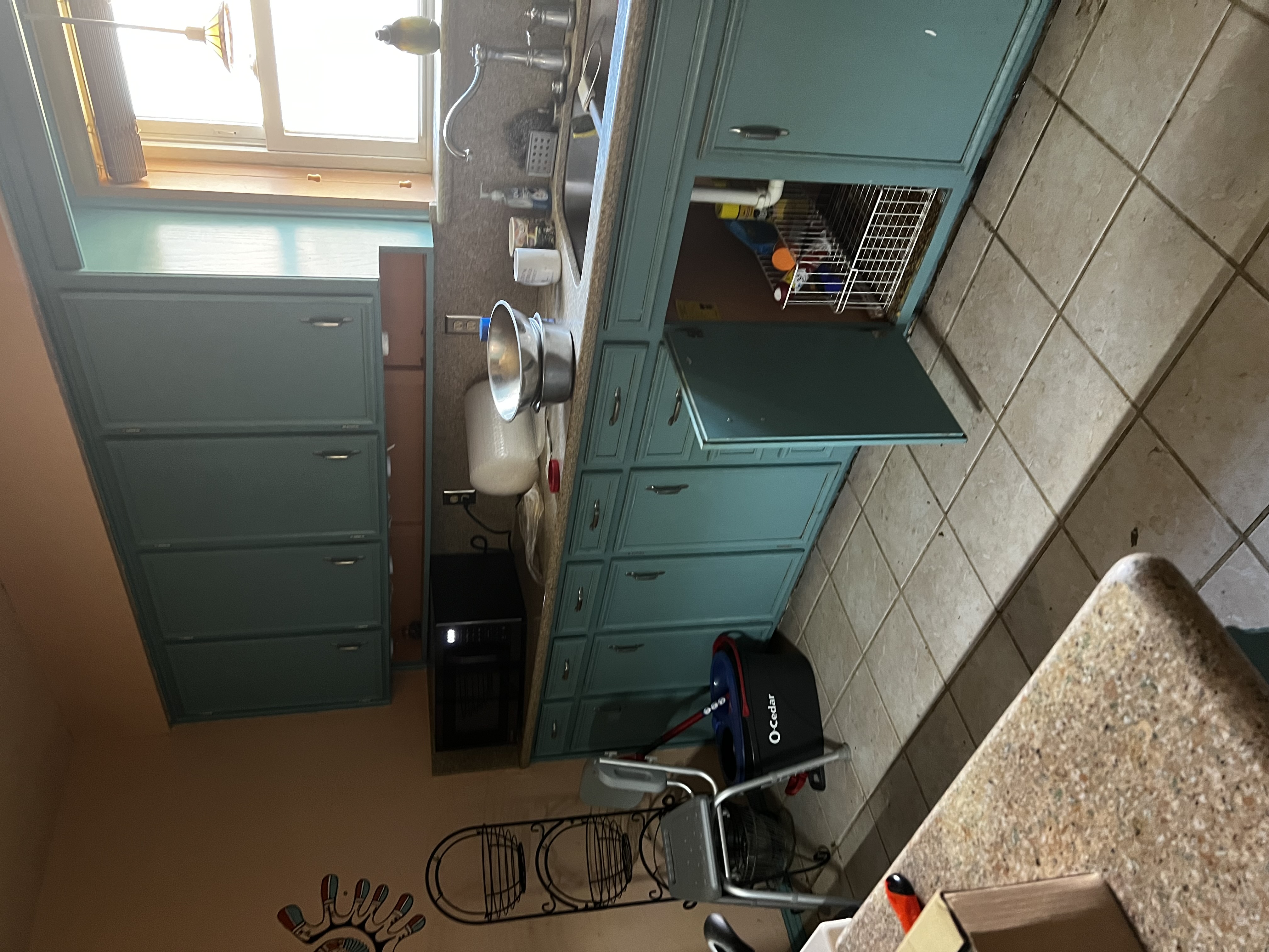 Dated kitchen with teal cabinets before remodel